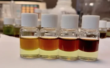 Чотири еталонні флакони PRO Test на кількість кокаїну, верхній шар від помаранчевого при 25% до майже чорного при 100%